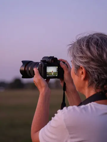 A photographer checks a shot on the camera screen at sunset